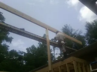 Carpenter setting a ridge beam over a new addition frame — Ice Dam Removal by Roofing Brothers in Richmond Dale