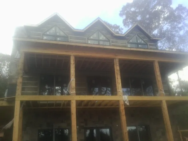 Dormers and porch framing on a large log home under construction — Roof Coating work by our crew in Richmond Dale