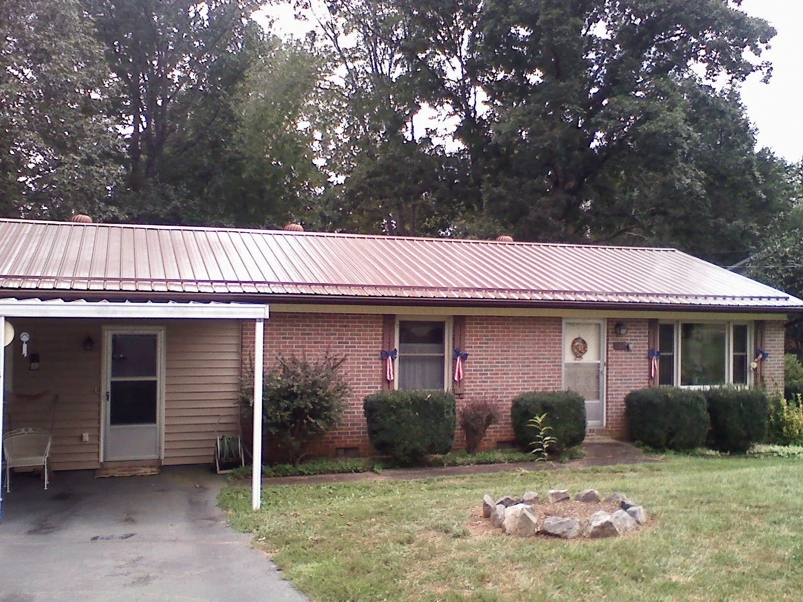 Bronze metal roof and carport on a brick ranch home — Roof Repair work by our crew in Richmond Dale